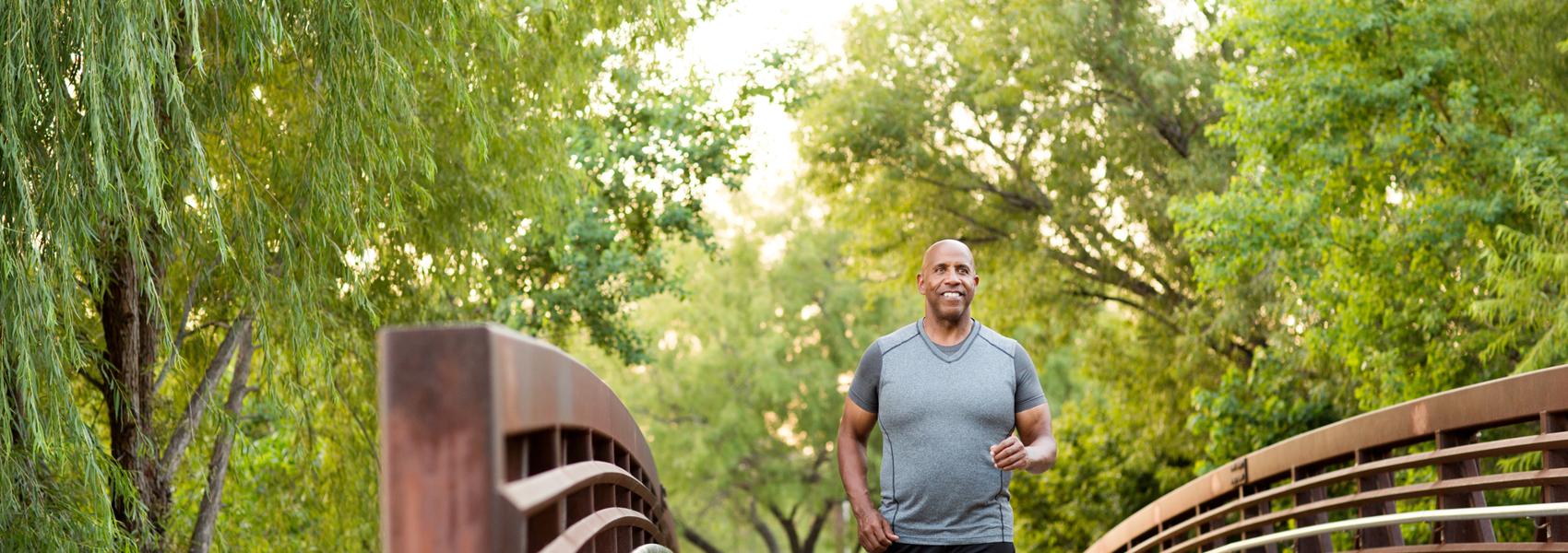 Mature African American man walking in the park.