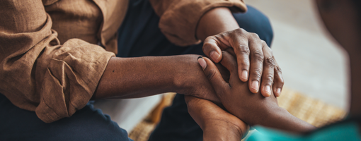 Closeup of a support hands. Closeup shot of a young woman holding a senior man's hands in comfort. Female carer holding hands of senior man