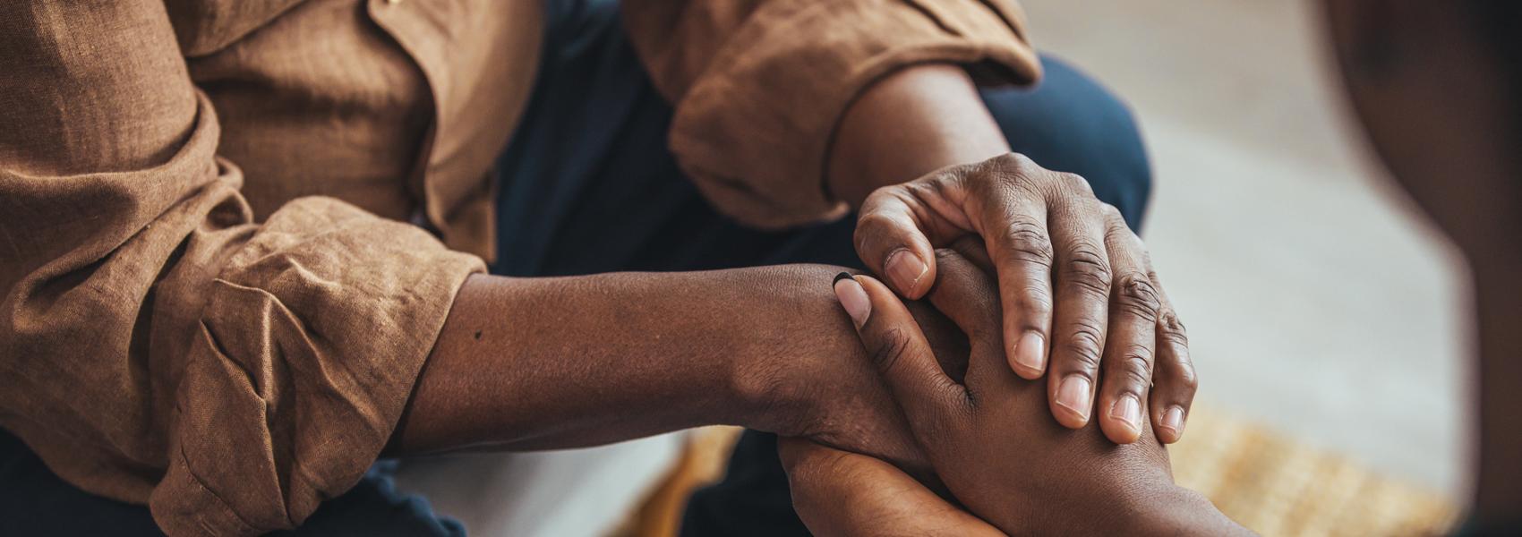 Closeup of a support hands. Closeup shot of a young woman holding a senior man's hands in comfort. Female carer holding hands of senior man