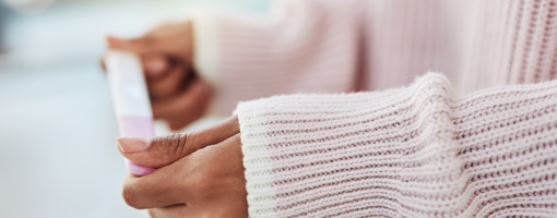 Cropped shot of an unrecognizable woman sitting on her bed alone and waiting for a pregnancy test result at home