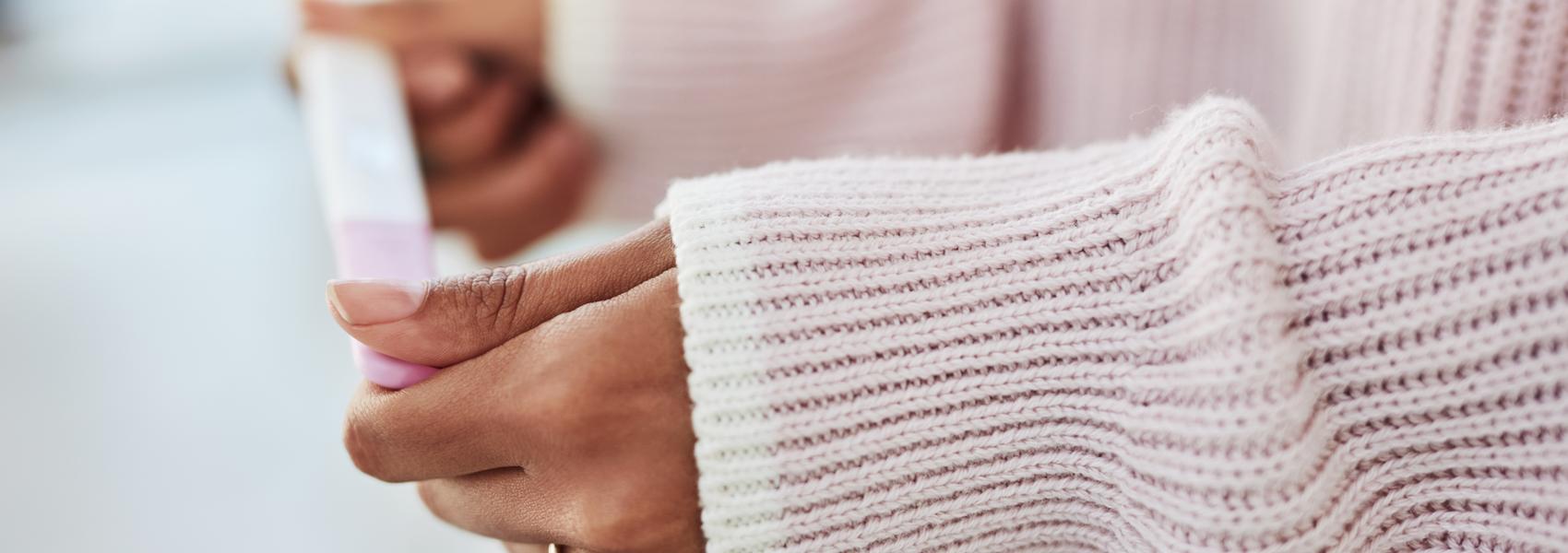 Cropped shot of an unrecognizable woman sitting on her bed alone and waiting for a pregnancy test result at home