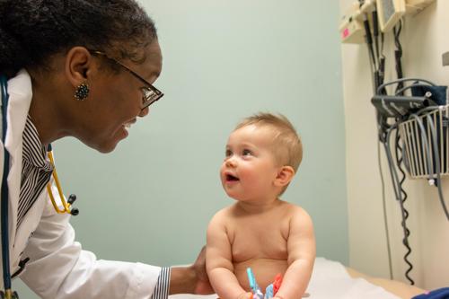 Pediatrician Dr. Hatcher gets smile from baby.