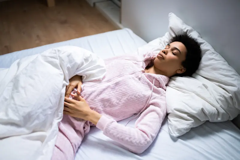 African American Woman With Stomach Pain Sleeping